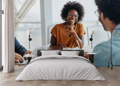 Black business woman leading a group of colleagues in a modern office boardroom Wall mural