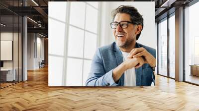 Business man looking outside the window in an office Wall mural