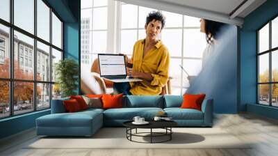 Business woman discussing a project report with her colleagues Wall mural