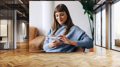 Businesswoman using a mobile phone in an office lobby Wall mural