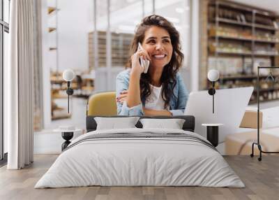 Cheerful businesswoman speaking on the phone in a warehouse Wall mural