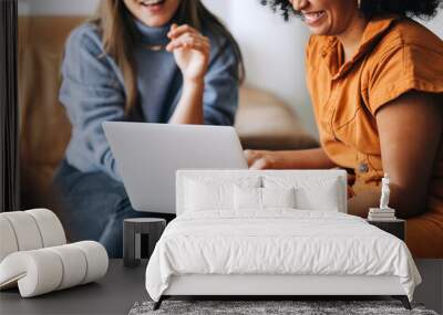 Cheerful businesswomen using a laptop together in an office lobby Wall mural