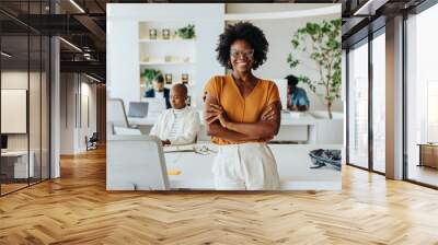 Confident black woman with afro hair smiling in a startup office Wall mural