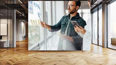 Creative business people brainstorming with sticky notes in an office Wall mural