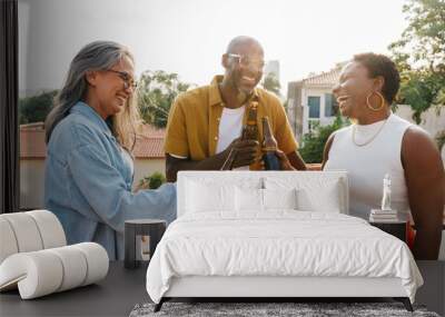 Diverse friends cheering with drinks outdoors, celebrating a joyful moment together Wall mural