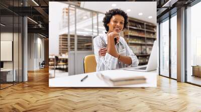 Ethnic entrepreneur smiling at the camera in a warehouse Wall mural