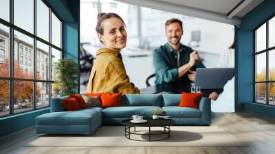 Female designer having a meeting with her team in an office Wall mural