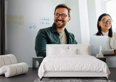 Happy business man listening to a discussion in an office Wall mural