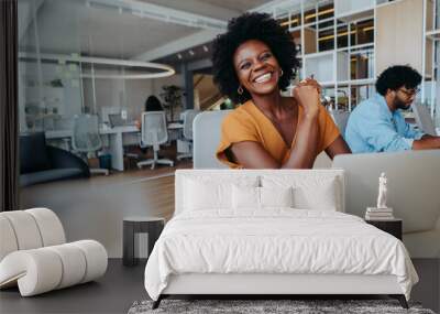 Happy business woman smiling in office boardroom with a laptop Wall mural