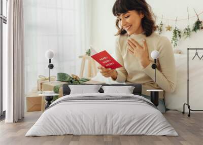 Happy woman reading a christmas greeting card Wall mural