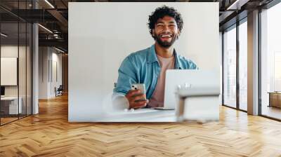 Happy young businessman working with technology for communication and connectivity in his office Wall mural