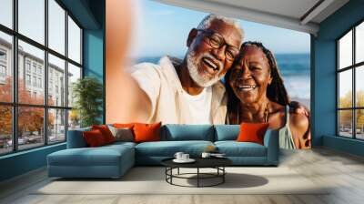 Joyful senior African American couple taking a selfie by the sea Wall mural