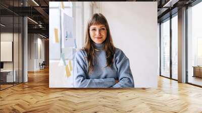 Portrait of a young businesswoman looking at the camera in an office Wall mural