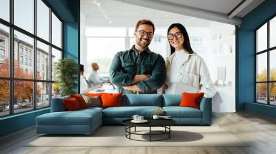 Portrait of two business people standing in an office Wall mural