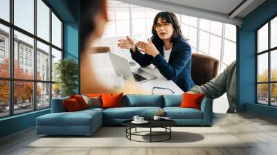 Professional woman talking to her team in an office meeting Wall mural