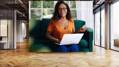 Retired woman buying from online stores using a gold credit card Wall mural