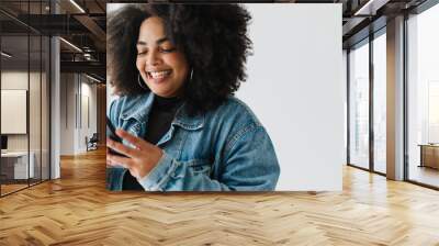 Smiling woman using her mobile phone Wall mural