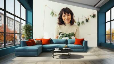 Smiling woman with a christmas present Wall mural