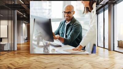 Software engineers using a computer and having a discussion in an office Wall mural