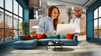 Teamwork in a cafe: Two business professionals using a laptop during a business lunch Wall mural