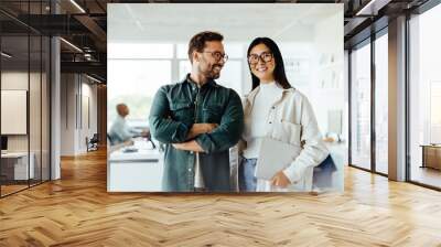 Two business people standing together in an office Wall mural