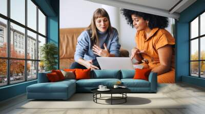 Two businesswomen having a discussion while looking at a laptop screen Wall mural