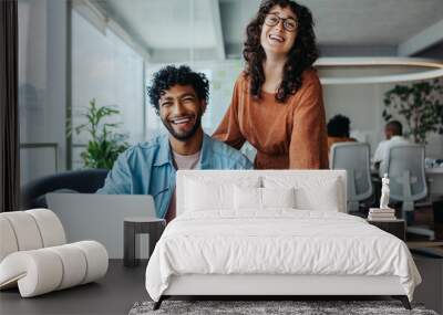 Two happy business people working together in a collaborative office environment Wall mural