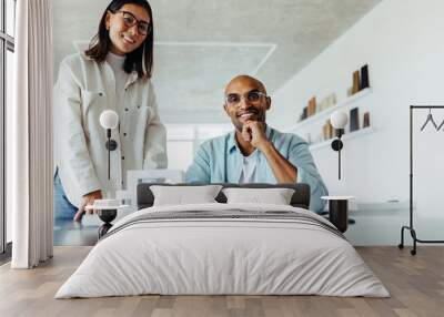 Two young architects working on a house model in an office Wall mural