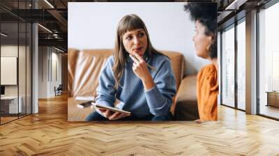 Two young business women having a discussion in an office lobby Wall mural