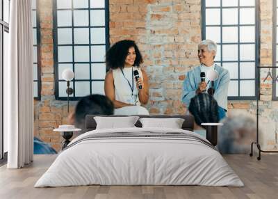 Women discussing business with audience Wall mural