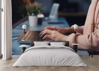 A close up of the female hands worinkg on the laptop, green flower on the background Wall mural