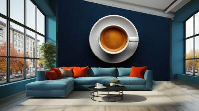 Espresso coffee in a cup on a saucer set against a dark blue background viewed from above Wall mural