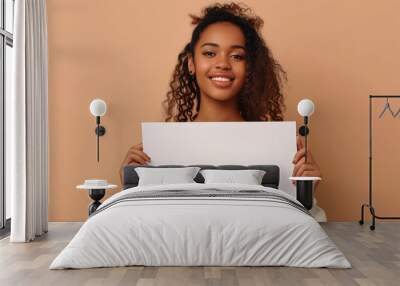 Latin young woman holding blank sign to enter text, isolated on pastel background Wall mural