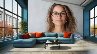 A relaxed and natural portrait of a woman wearing glasses, featuring a calm expression and casual attire, conveying serenity and a professional aura. Wall mural