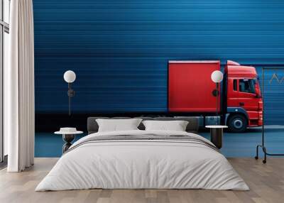 This image captures a bright red delivery truck in motion set against a static blue industrial background, highlighting contrast and motion in an urban setting. Wall mural