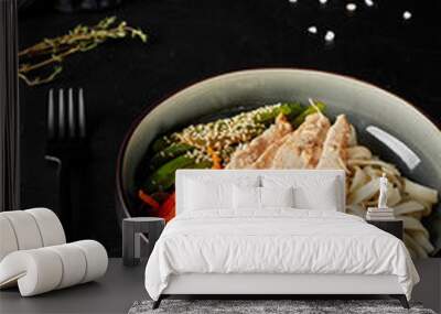 chinese noodles with meat and vegetables in a plate on black texture background Wall mural