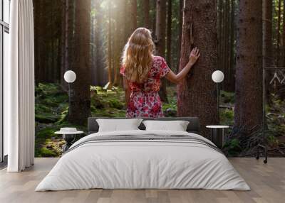 Beautiful blond woman in forest enjoys the silence and beauty of nature. Wall mural