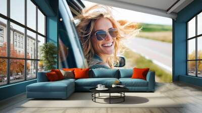 Pretty woman in sunglasses leant out of car window and takes selfie during summer travel, road trip. Wall mural