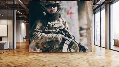 A bearded soldier in uniform of special forces in a dangerous military action in a dangerous enemy area. Selective focus  Wall mural