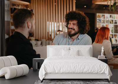 A group of friends hanging out in a cafe, and among them is a tablet. Wall mural