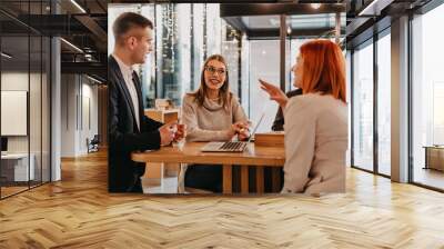 A group of friends hanging out in a cafe, and among them is a tablet. Wall mural