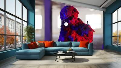 A professional soldier undertakes a perilous mission in an abandoned building illuminated by neon blue and purple lights Wall mural