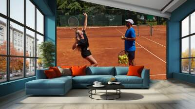 A professional tennis player and her coach training on a sunny day at the tennis court. Training and preparation of a professional tennis player Wall mural