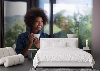 African American woman drinking coffee looking out the window Wall mural