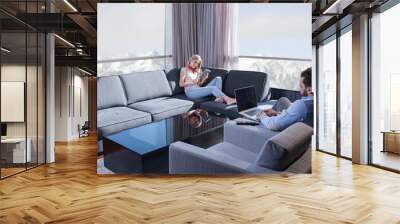 couple relaxing at  home using tablet and laptop computers Wall mural