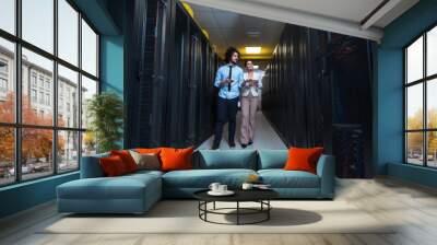 engineer showing working data center server room to female chief Wall mural