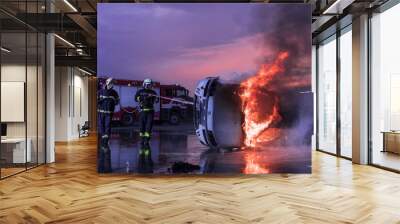 Firefighters using water fire extinguisher to fighting with the fire flame in car accident. Firefighter industrial and public safety concept rescue in night.  Wall mural