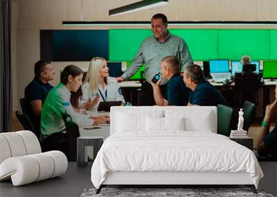 Group of security guards sitting and having briefing In the system control room They're working in security data center surrounded by multiple Screens Wall mural