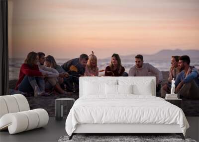 Group Of Young Friends Sitting By The Fire at beach Wall mural