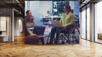 Handicapperd businesswoman in a wheelchair on meeting with her diverse business team brainstorming at office Wall mural